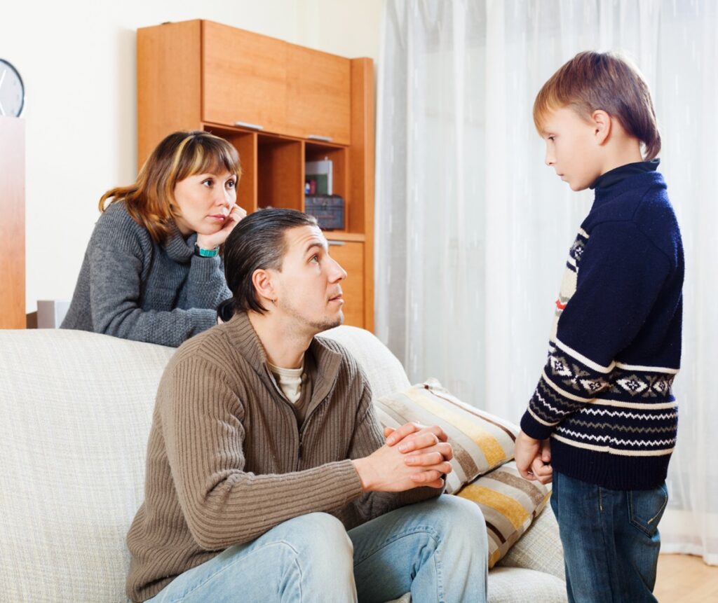 Pais conversando atentamente com seu filho, demonstrando empatia e compreensão na comunicação familiar.