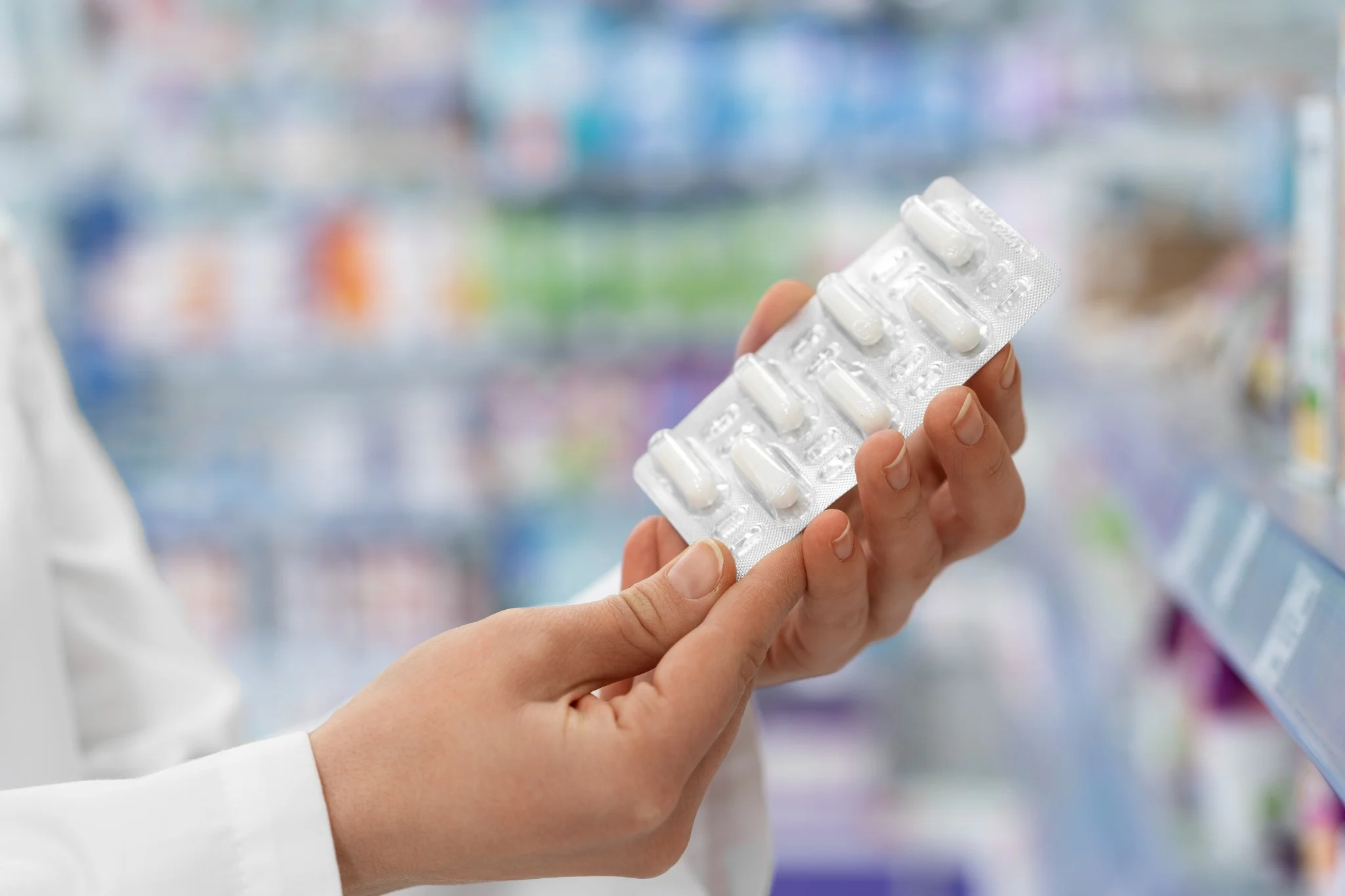 Farmacêutico segurando embalagem de medicamento em farmácia