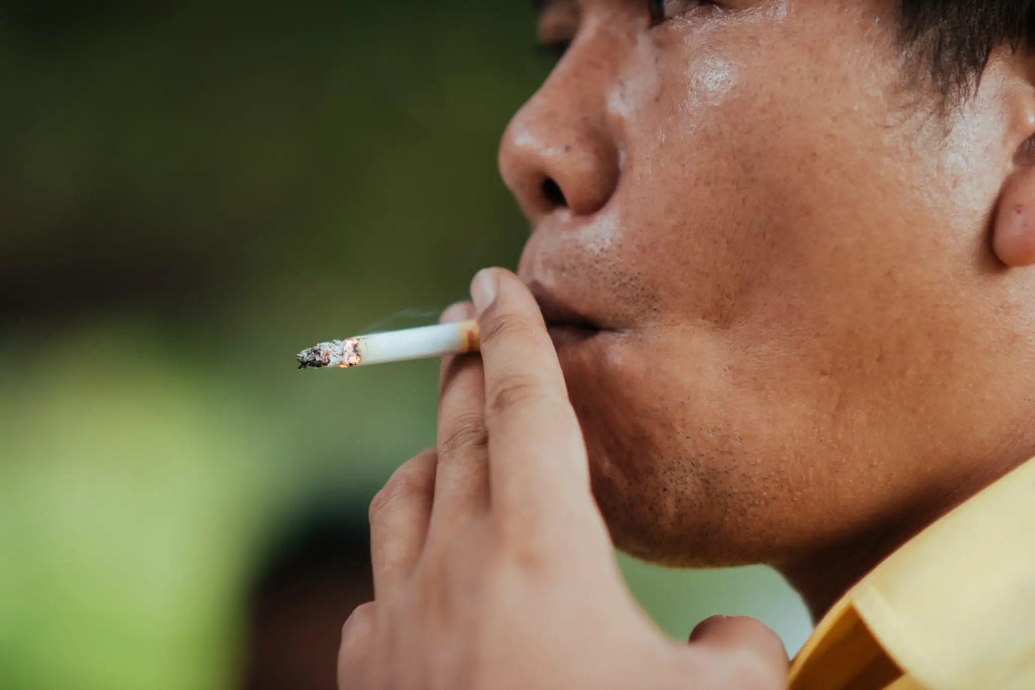 Homem fumando cigarro, ideal para ilustrar temas sobre abstinência do tabaco