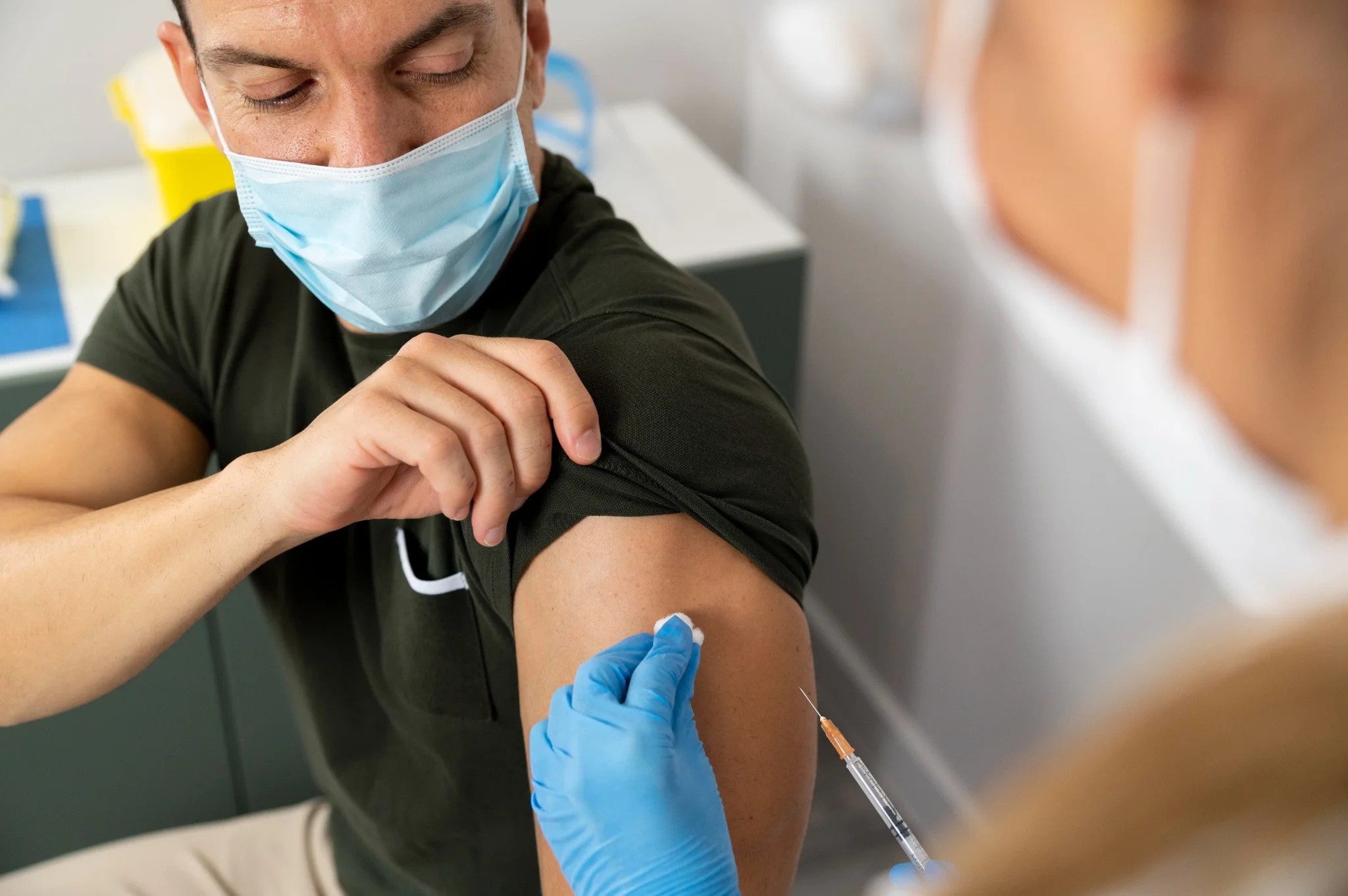Homem recebendo vacina contra doenças em ambiente clínico, com foco na vacina contra a dengue esperada para 2026.